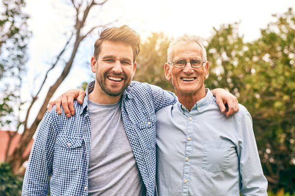 Jim and Mike Burke smiling together outdoors. Father and son, two generations of Charlotte plumbers